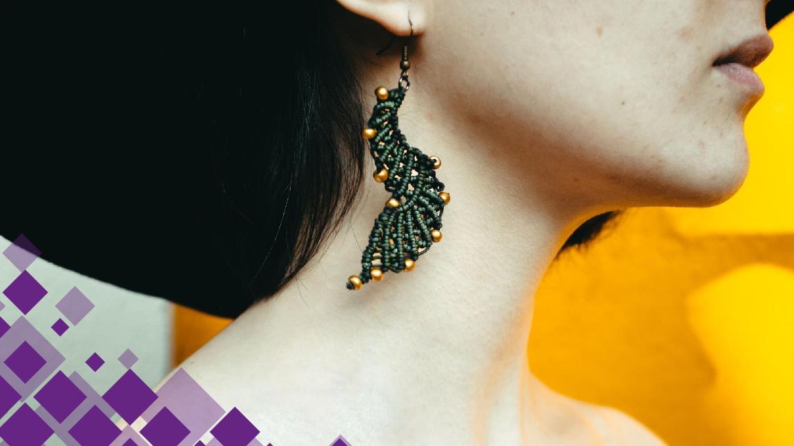 Une boucle d'oreille avec des perles vertes et dorées.